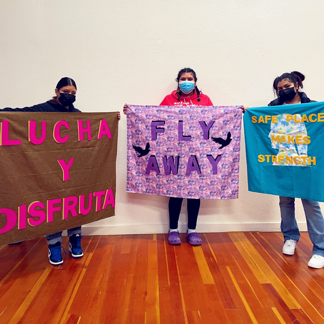 Protest + Print girls hold their flags.