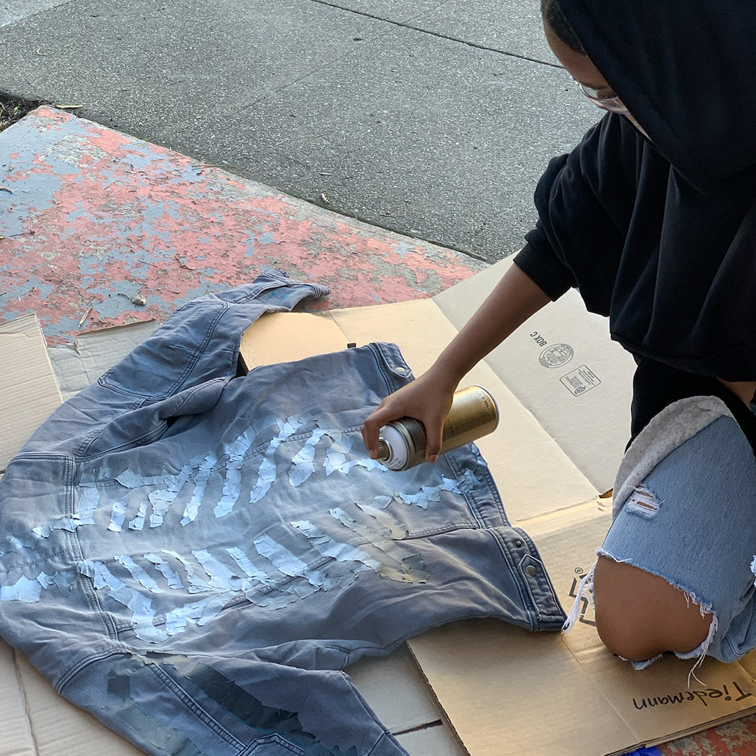Girls Garage spray painting a jacket