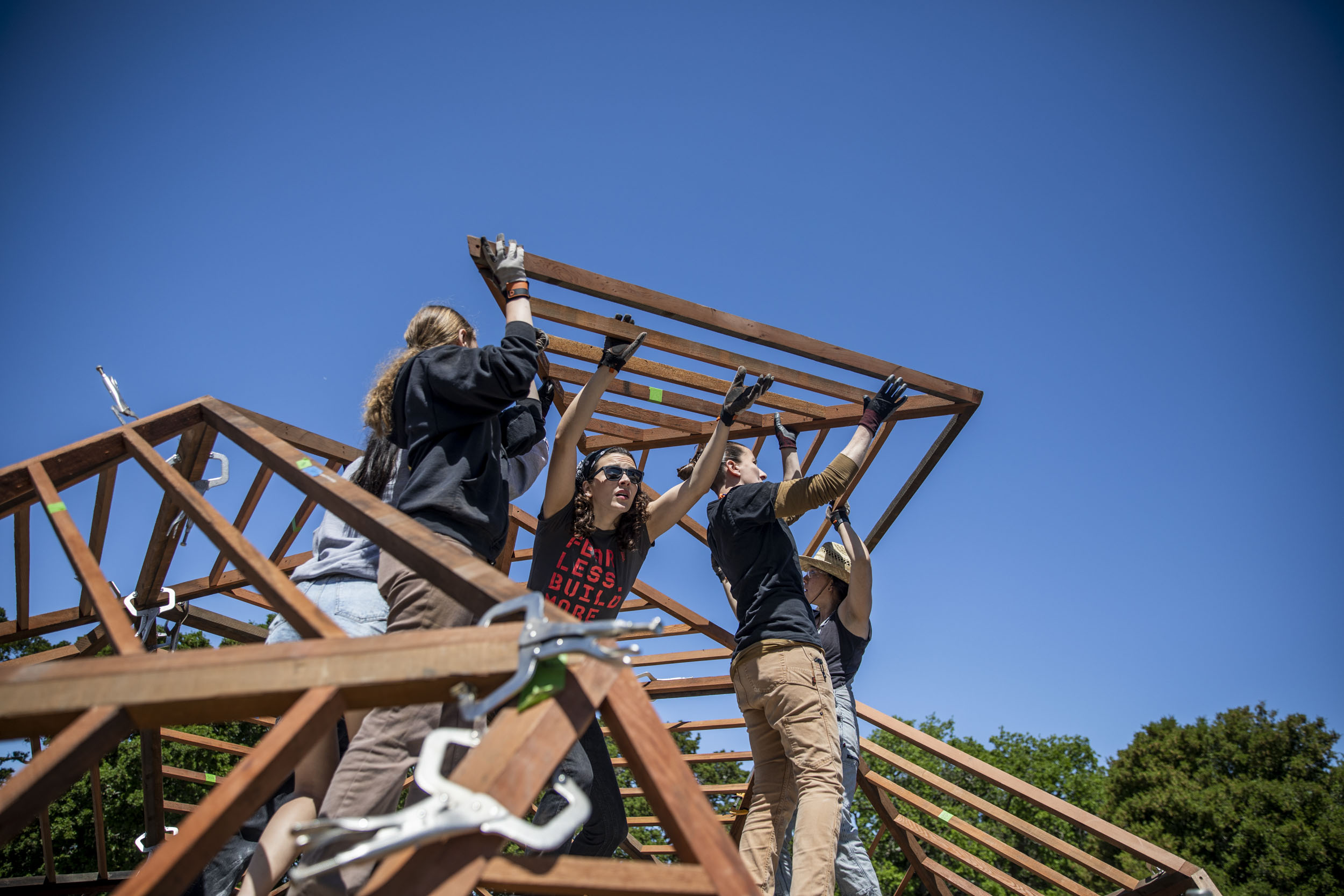 Students and instructors installing a triangular frame for geodesic dome